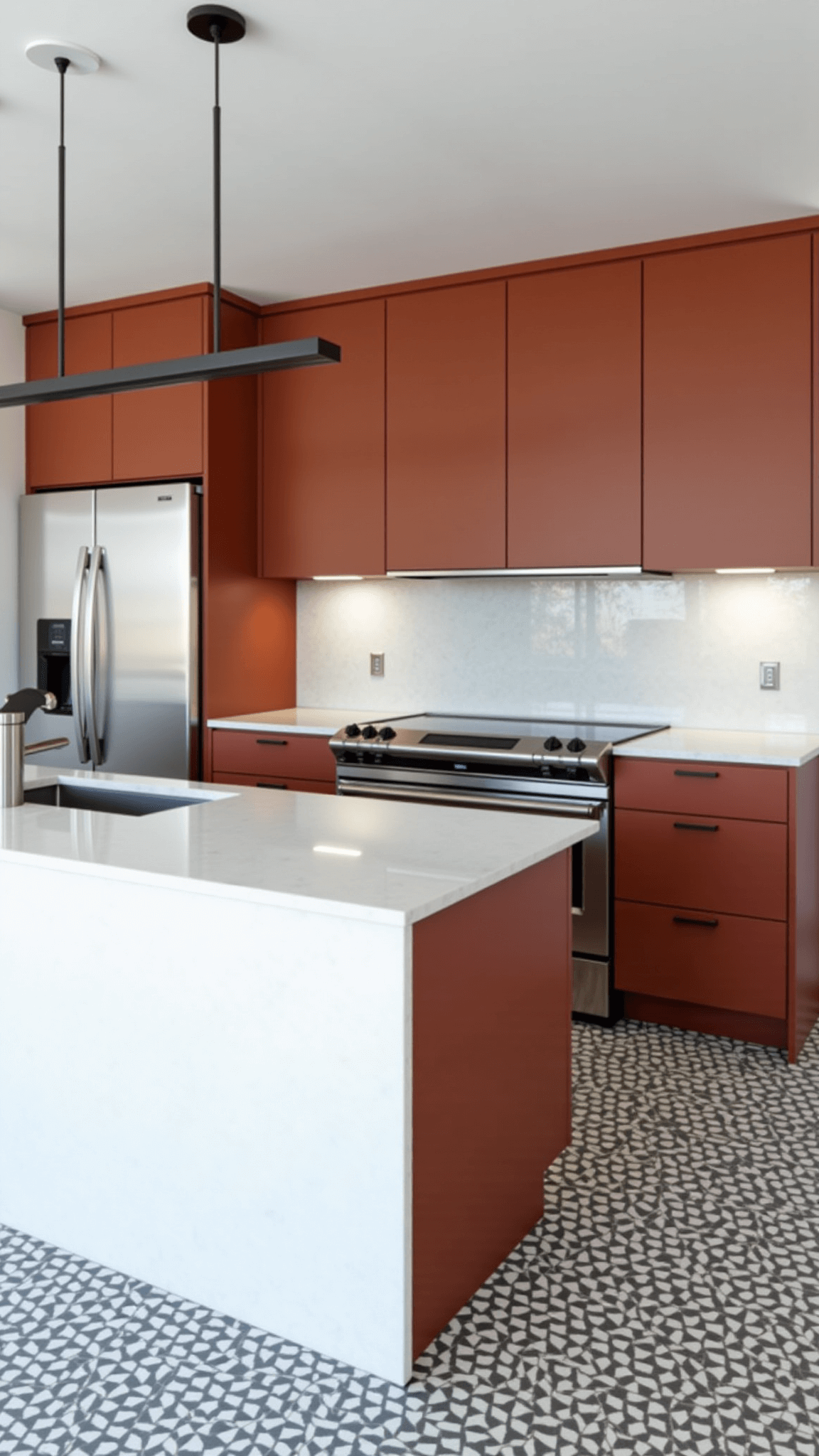 High-angle view of a contemporary minimalist kitchen with terracotta cabinets, stainless steel appliances, white quartz waterfall island, geometric cement tile flooring, and slim black pendant lights.